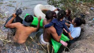 Migrantes, ayudados de un inflable, intentan cruzar el Río Bravo. Foto: EFE