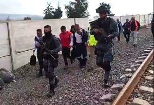 De chaleoco rojo, el conductor de la máquina que causó la muerte de seis personas en Irapuato, es escoltado por policías.