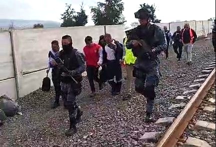 De chaleoco rojo, el conductor de la máquina que causó la muerte de seis personas en Irapuato, es escoltado por policías.