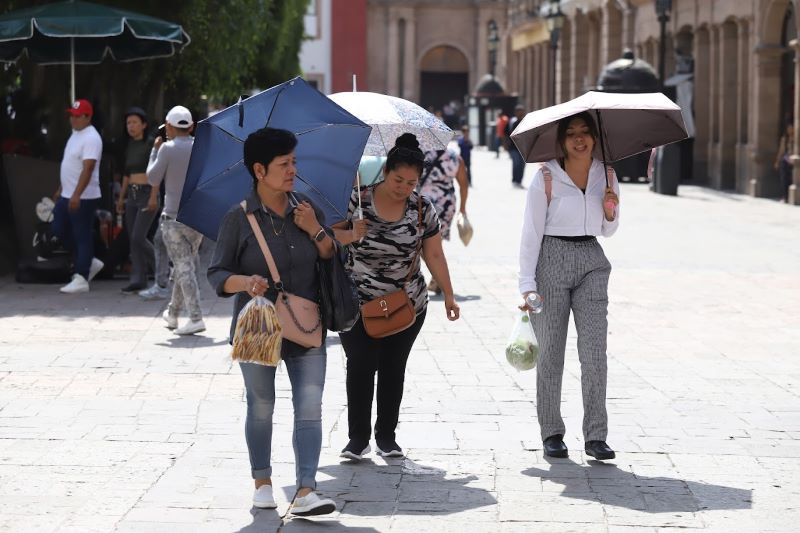 Calor, gente con sombrilla.